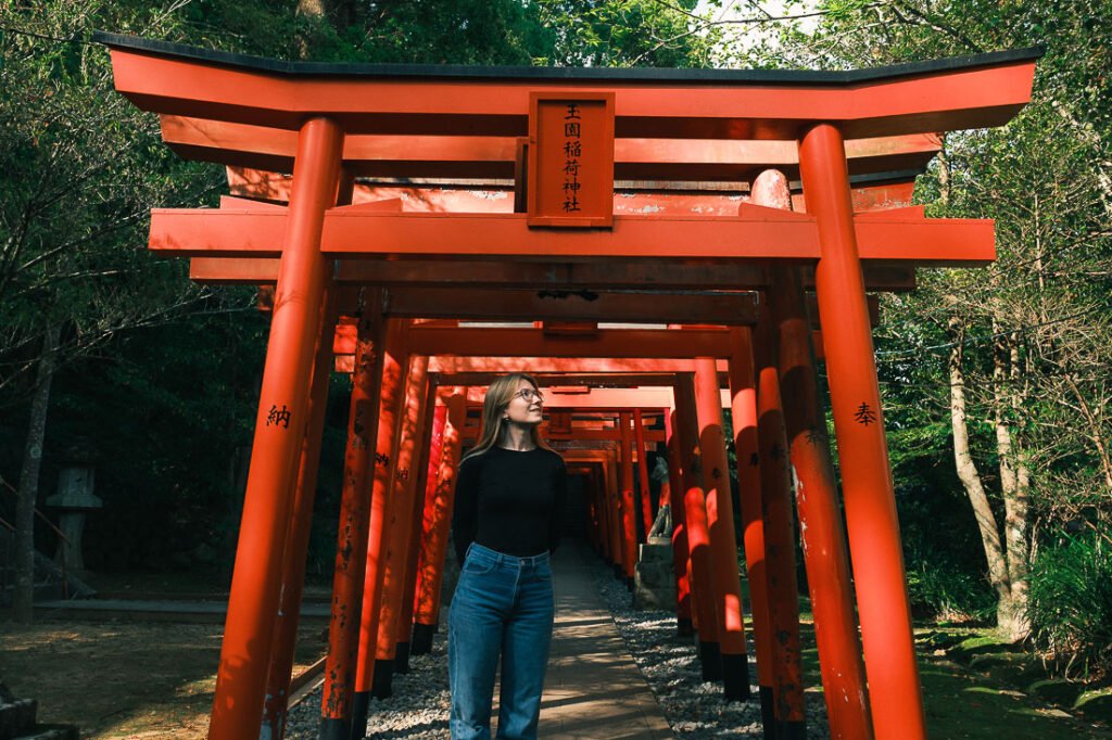 Julie en dessous d'un ensemble de torii rouges