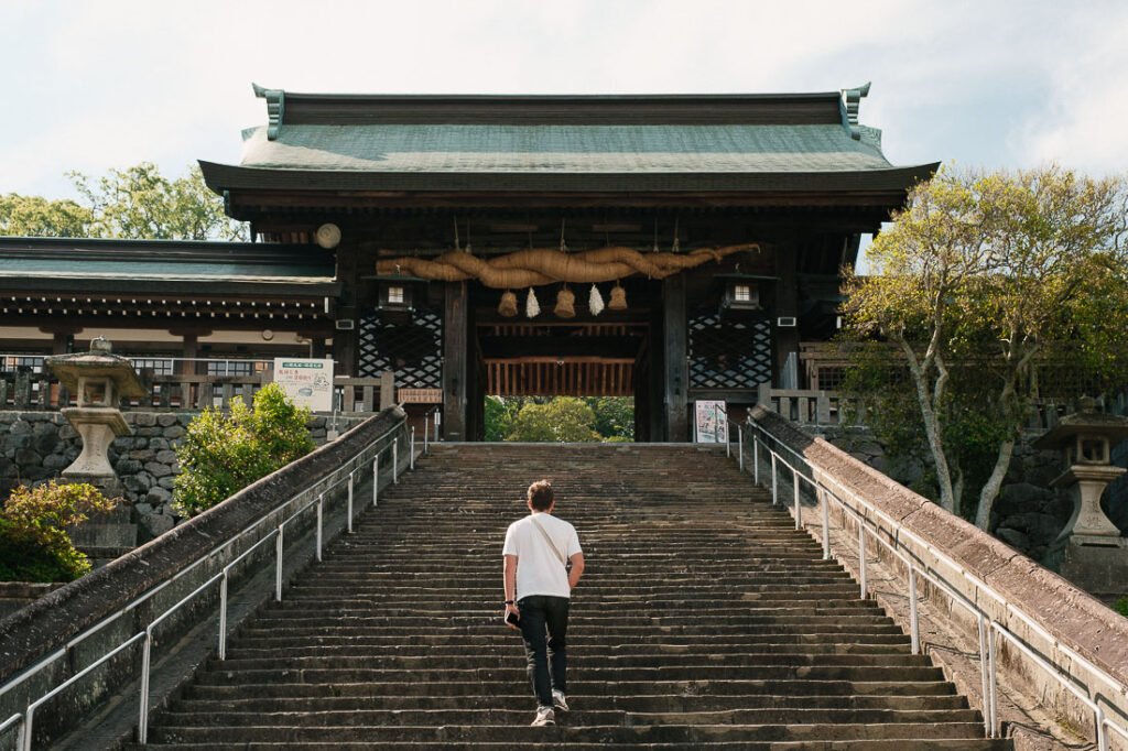 Paul-Louis marche vers l'entrée d'un temple avec une grande porte