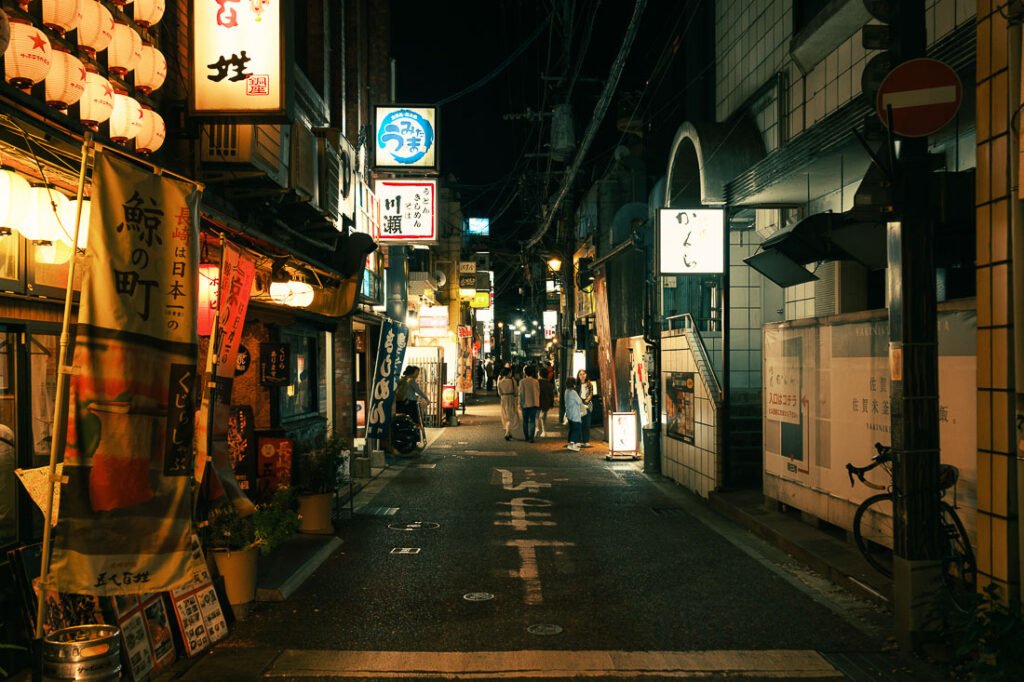 Rue de Nagasaki de nuit avec des enseignes illuminées