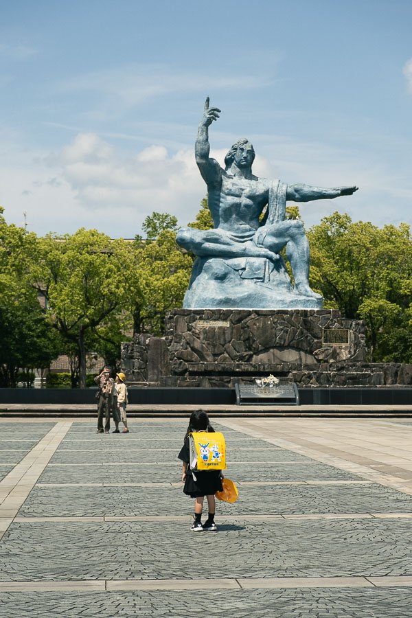 Une fillette devant la statue de la paix à Nagasaki