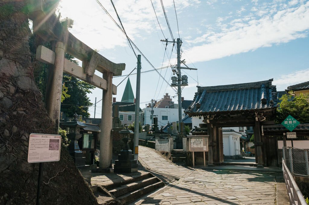 Une entrée de temple bouddhiste, torii shinto et église chrétienne